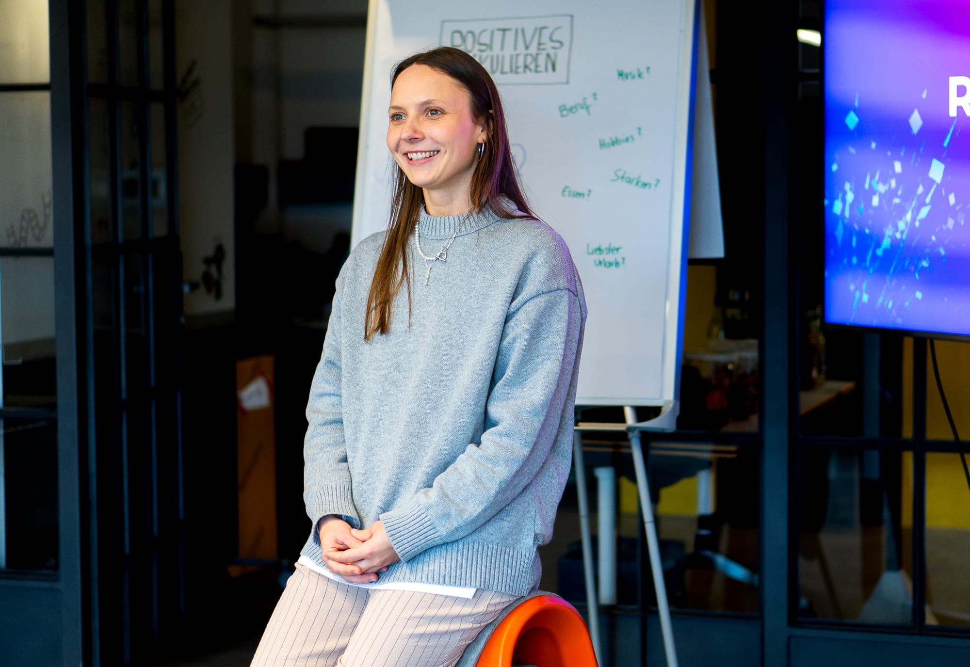 Jule, Trainerin der Junge Wilde Academy, lachend bei einer Präsentation am Flipchart